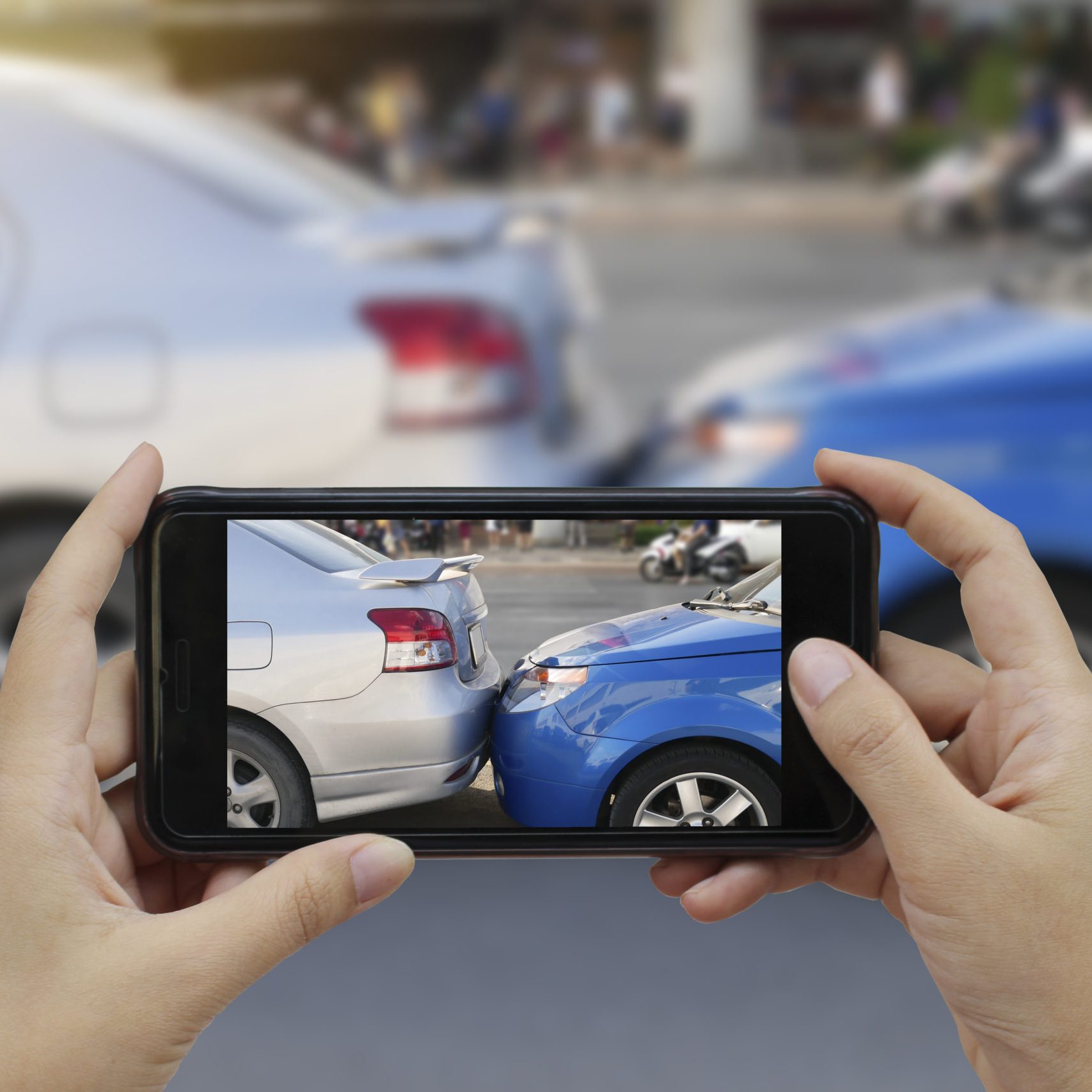 Close up hand holding smartphone and take photo at The scene of a car crash and accident, car accident for car insuranc claim.